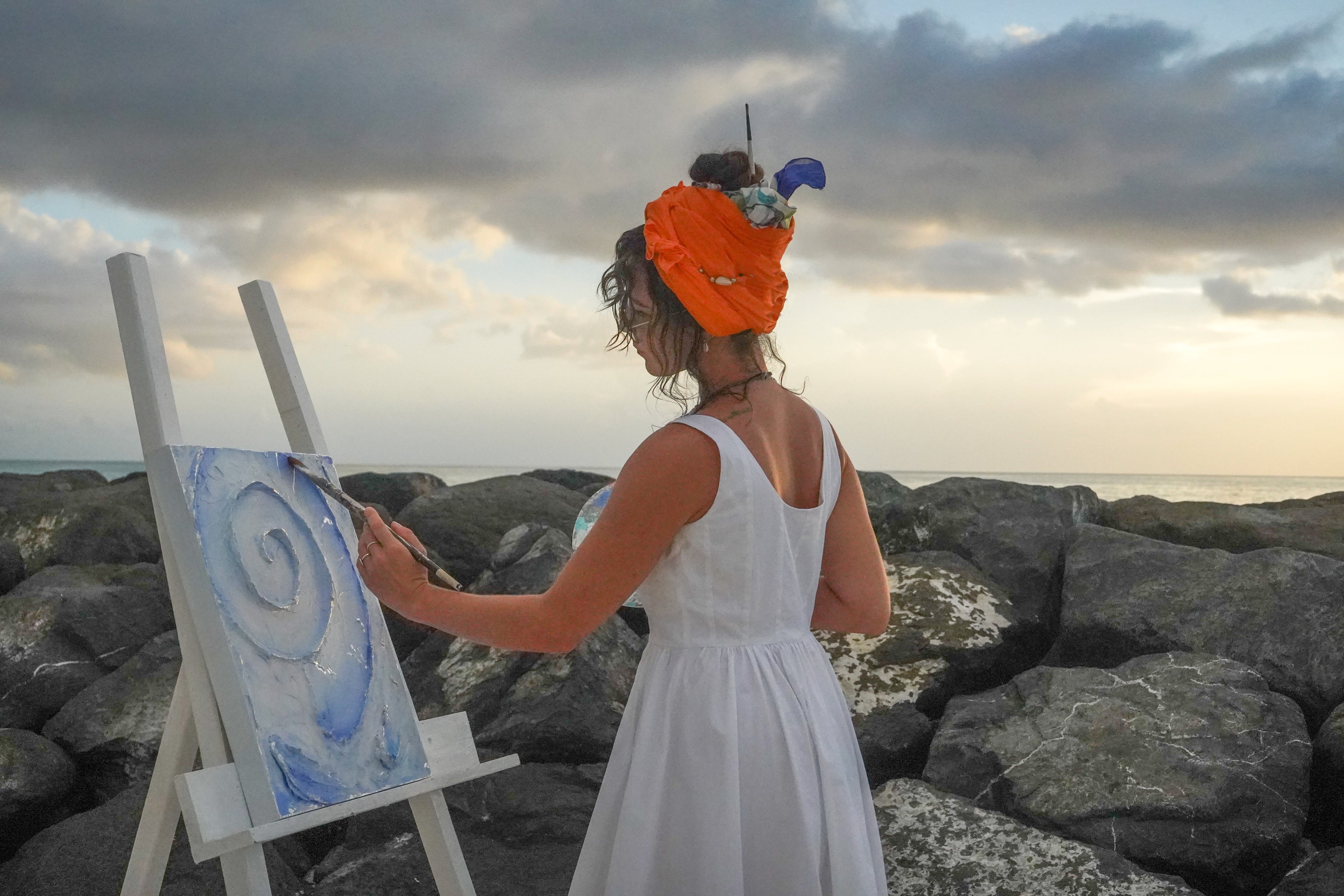 Fine Art, Artist Fay Ninon painting by the turquoise Gracebay beach in Turks and Caicos
